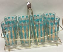 A set of eight retro glasses in matching stand.