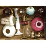 A box containing old oil lamps and shades.