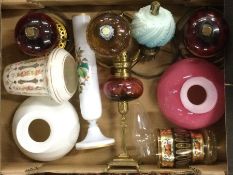 A box containing old oil lamps and shades.