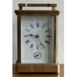 A large brass carriage clock with white enamel dial.