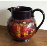 WILLIAM MOORCROFT: A jug of flambé leaf and berries design.