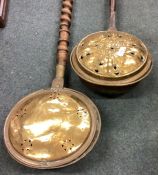 A good Georgian brass mounted warming pan with barley twist handle with one other.