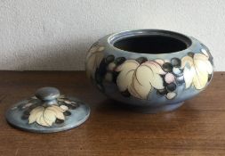 WILLIAM MOORCROFT: A leaf and berries salt glaze circular vase and lid.