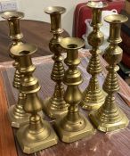 Three pairs of heavy brass candlesticks.