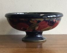 WILLIAM MOORCROFT: A footed bowl of pomegranate design with Burslem markings.