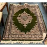 A good green ground rug with central medallion.