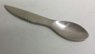 A combination silver spoon and knife.