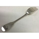 PAUL STORR: A large fiddle pattern silver table fork with crested terminal.