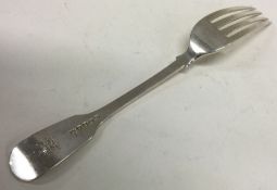PAUL STORR: A large fiddle pattern silver table fork with crested terminal.