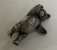 A novelty early 20th Century silver brooch in the form of a teddy bear with articulated limbs.