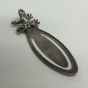 A silver bookmark with frog decoration.