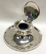 A massive circular silver capstan inkwell of stylised form with hinged top. Birmingham.