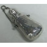 A Victorian silver scent bottle with hammered decoration bearing import marks.