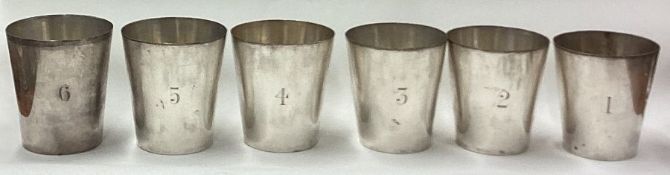 A set of six silver plated stacking beakers in case.