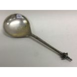 An Antique silver spoon with engraved figural finial.