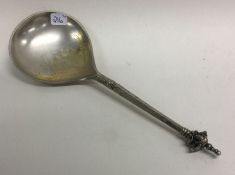 An Antique silver spoon with engraved figural finial.