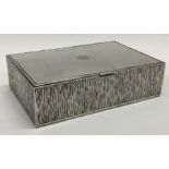 GERALD BENNEY: A fine quality hinged top silver cigarette box with crested decoration.