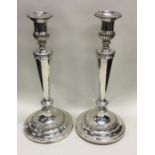 A good pair of tall Georgian silver candlesticks with crested armorials. London. By Mathew Bolton.