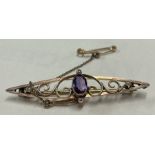 An amethyst brooch in 9 carat with scroll decoration.