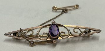 An amethyst brooch in 9 carat with scroll decoration.