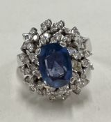 A heavy 18 carat gold sapphire and diamond modern cluster ring.