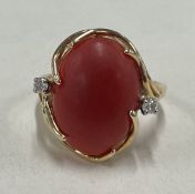 A 14 carat gold coral and diamond three stone ring.