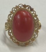 A heavy coral single stone ring in 18 carat gold setting.