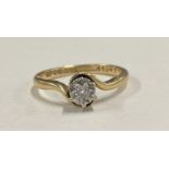 A small diamond single stone crossover ring in claw mount.