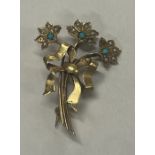 A small 9 carat brooch in the form of a flower.