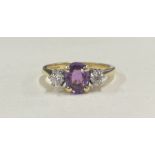 An amethyst and diamond three stone ring in 18 carat two colour gold claw mount.