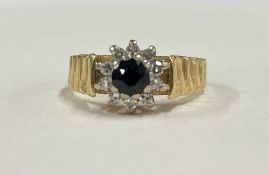 A sapphire and diamond circular cluster ring in 18 carat gold mount.