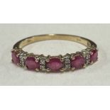 A ruby and diamond half eternity ring in 9 carat.