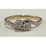 A small 18 carat gold diamond mounted two stone crossover ring.