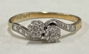 A small 18 carat gold diamond mounted two stone crossover ring.