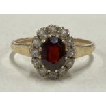 A circular garnet cluster ring in 9 carat claw mount.