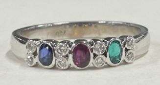 A heavy ruby, emerald, sapphire and diamond cluster ring in 18 carat white gold.