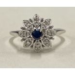 A sapphire and diamond circular cluster ring in 18 carat white gold.