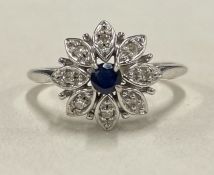 A sapphire and diamond circular cluster ring in 18 carat white gold.