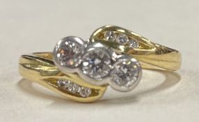 An attractive diamond three stone crossover ring in 18 carat gold two colour setting.