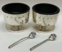 GERALD BENNEY: A good heavy pair of circular silver salts with crested decoration.