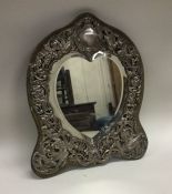 A large silver easle back mirror of heart shaped form.