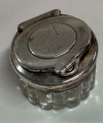 A Victorian silver and glass inkwell with screw-top lid.