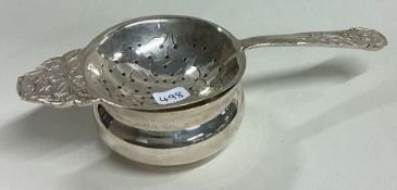 R E STONE: A rare Arts & Crafts silver tea strainer on stand. London 1948. Signed and fully marked.