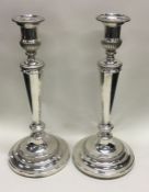 A good pair of tall Georgian silver candlesticks with crested armorials. London. By Mathew Bolton.