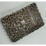 A chased Indian silver card case embossed with flowers.