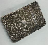 A chased Indian silver card case embossed with flowers.