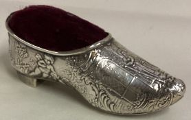 A chased 19th Century silver pin cushion in the form of a shoe.
