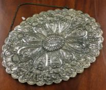 A large Continental silver oval mirror decorated with flowers and leaves.