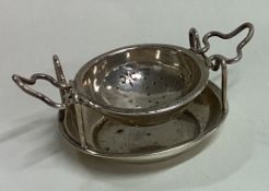 A silver tea strainer on stand. Birmingham 1931.