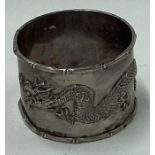 A Chinese export silver napkin ring decorated with a dragon.